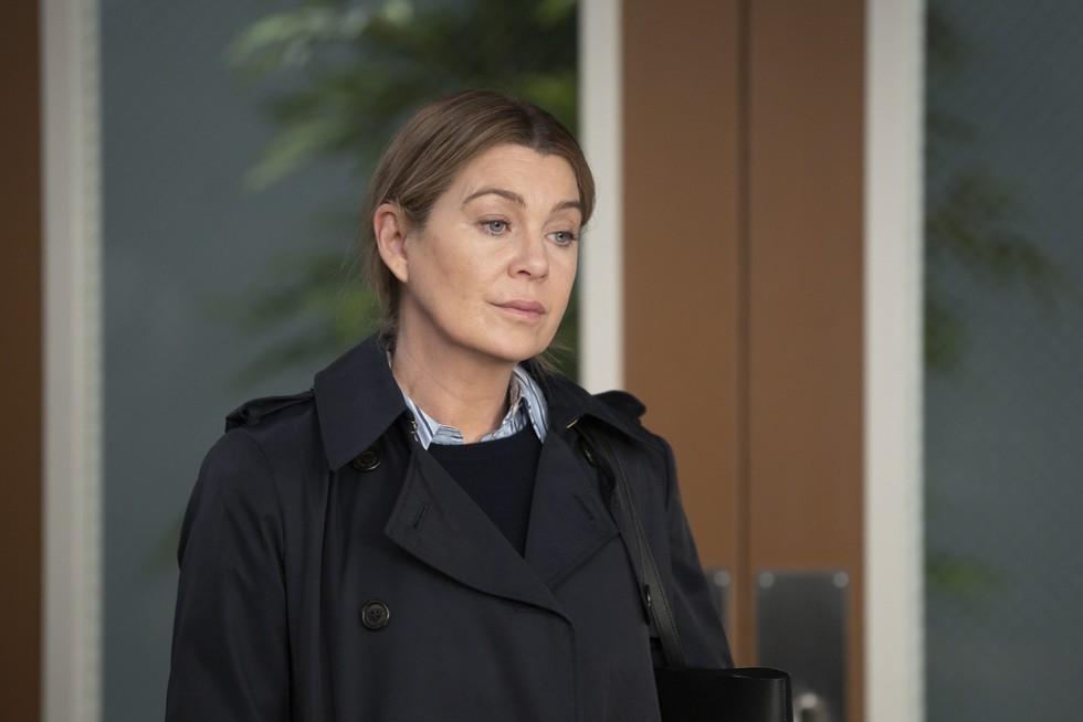ELLEN POMPEO Ellen Pompeo standing in a hospital office in a black coat as Dr Meredith Grey in Grey's Anatomy.
