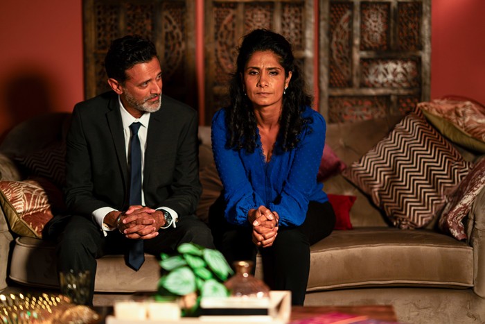 Nish Suki EastEnders. Nish watches uneasy Suki in EastEnders as they sit on a sofa