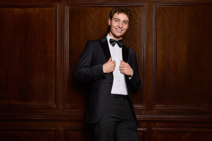 Freddy Knatchbull for Made in Chelsea Freddy Knatchbull wearing a tuxedo. He is smiling and is holding the lapels of his blazer.