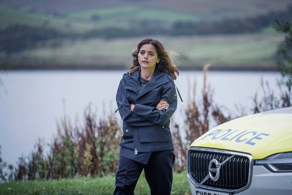 Jenna Coleman as Ember in The Jetty Jenna Coleman as Ember in The Jetty walking past a police car with arms folded