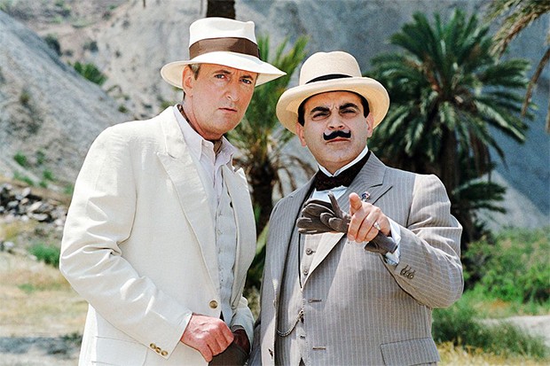 David Suchet as Hercule Poirot David Suchet as Hercule Poirot standing next to a man in a white linen suit looking into camera