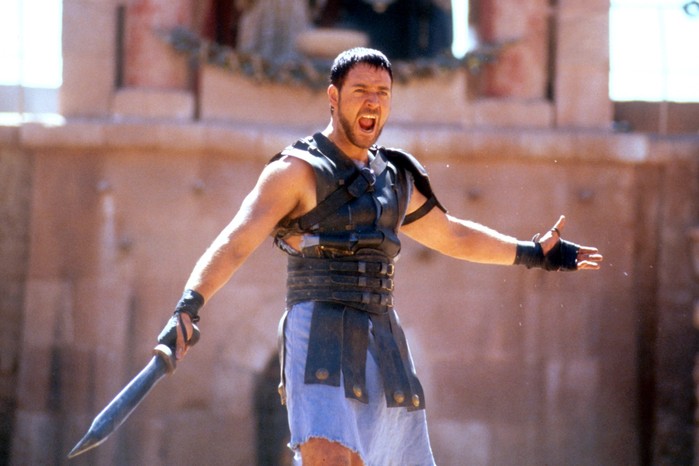 gladiator-russell-crowe Russell Crowe stars in Gladiator (2000) in gladiatorial gear holding a sword, screaming