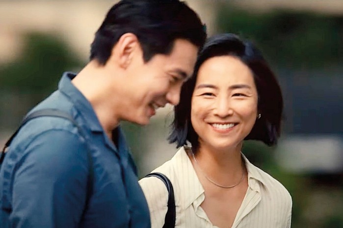 Greta Lee as Nora and Teo Yoo as Hae Sung in Past Lives Greta Lee as Nora and Teo Yoo as Hae Sung in Past Lives smiling together