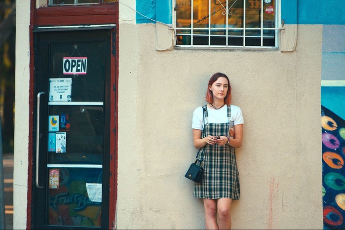 Lady-Bird Saoirse Ronan in Lady Bird leaning against a wall in a plaid dress