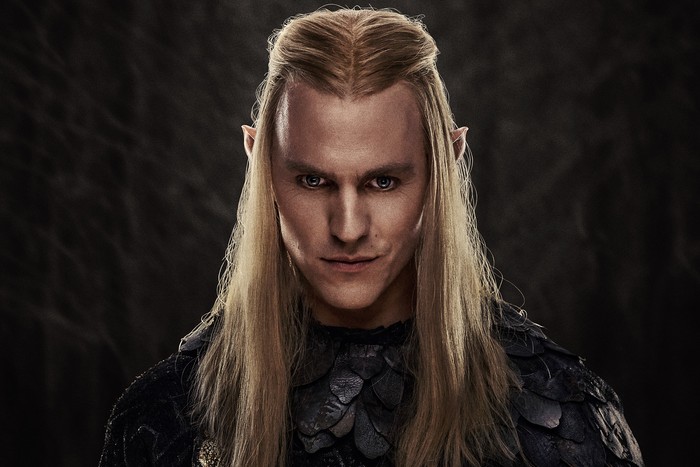 lord-of-the-rings-rings-of-power-s2-Sauron Charlie Vickers as Sauron standing and looking into the camera wearing a black suit with long blonde hair.