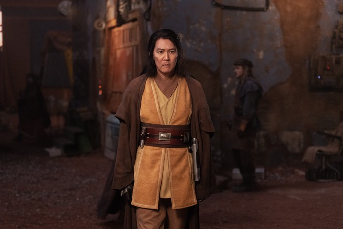 Lee Jung-jae as Master Sol in The Acolyte Lee Jung-jae as Master Sol in The Acolyte in a brown and yellow robe with lightsaber on his belt