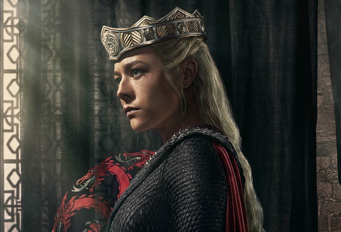 queen-rhaenyra-targaryen Emma D'Arcy as Queen Rhaenyra Targaryen in a crowd and black roads in front of a black curtain with red dragon Targaryen crest for House of the Dragon season 2.