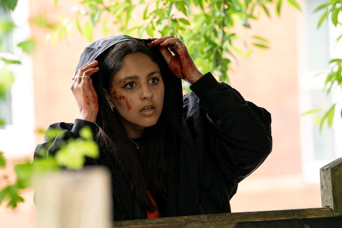 rhianne-barreto-outlaws Rani takes off her coat hood, with blood splattered across her hands and face