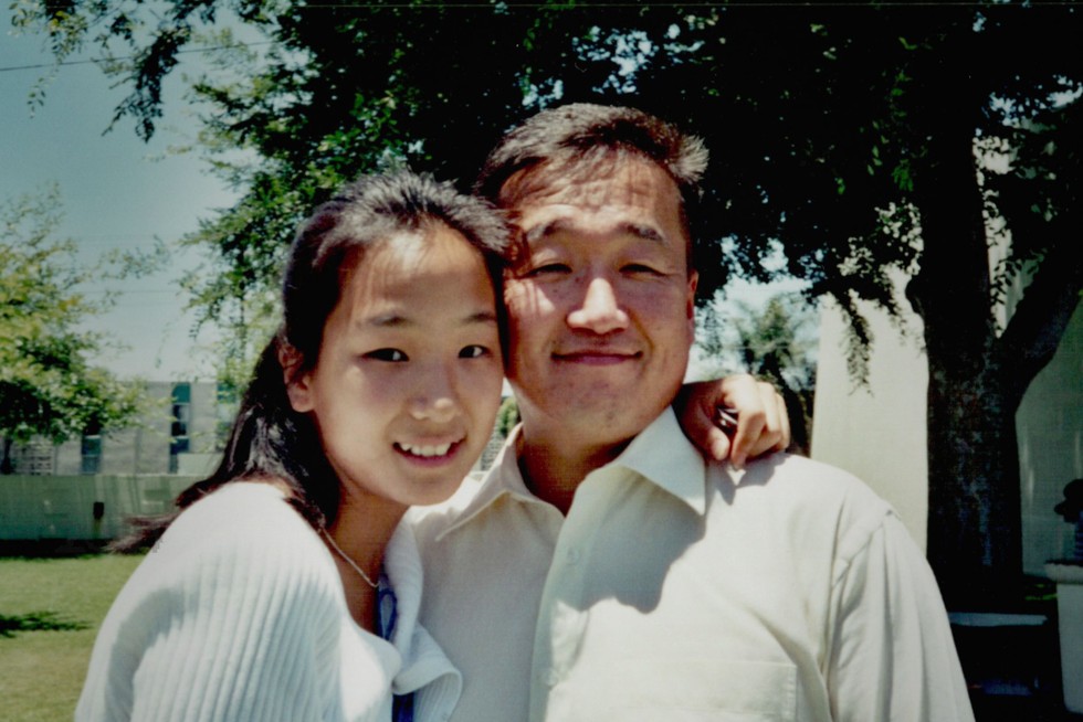 Melanie Lee and Robert Shinn Melanie Lee and Robert Shinn. They are smiling and posing next to one another with Melanie's arm around his neck.