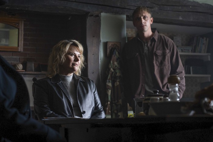 480712,Sherwood - Series 2 Monica Dolan as Ann Branson and Perry Fitzpatrick as Rory Sparrow in Sherwood. She is sat behind a desk and he is stood next to her.
