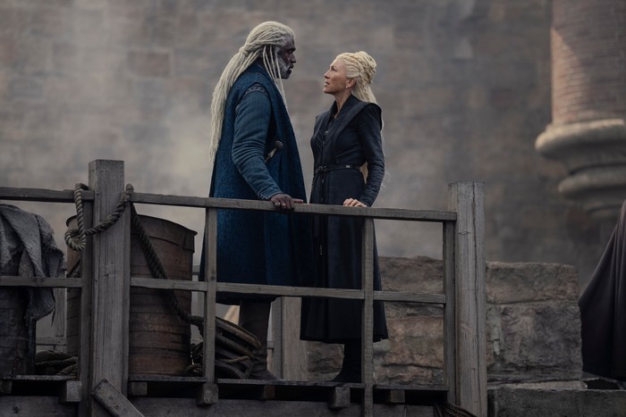 steve-toussaint-eve-best (1) Steve Toussaint as Lord Corlys Velaryon standing on battlement with Eve Best as Princess Rhaenys Targaryen in House of the Dragon season 2.