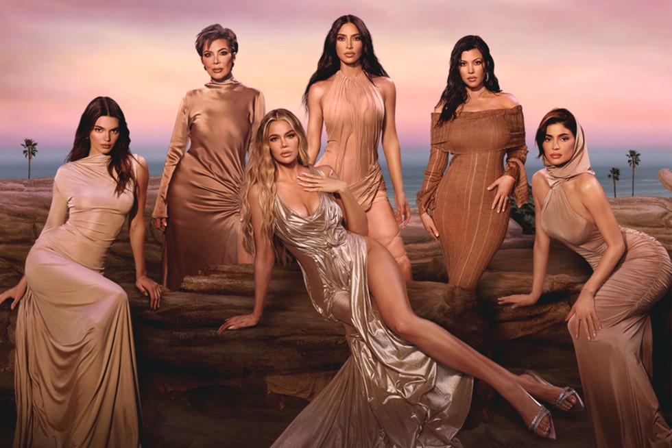 The Kardashians The Kardashian-Jenner family all wearing tanned clothing, looking ahead with pout expressions.