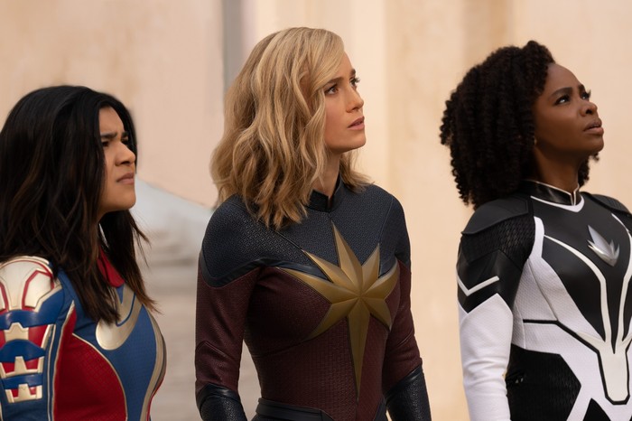 the-marvels Ms. Marvel (Iman Vellani), Captain Marvel (Brie Larson) and Monica Rambeau (Teyonah Parris) in The Marvels looking skywards, confused