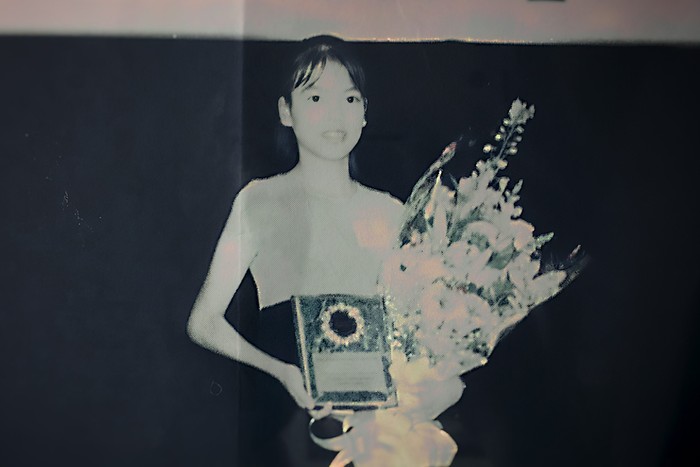 Jennifer Pan from What Jennifer Did A photo go a young Jennifer Pan holding flowers and a framed certificate.